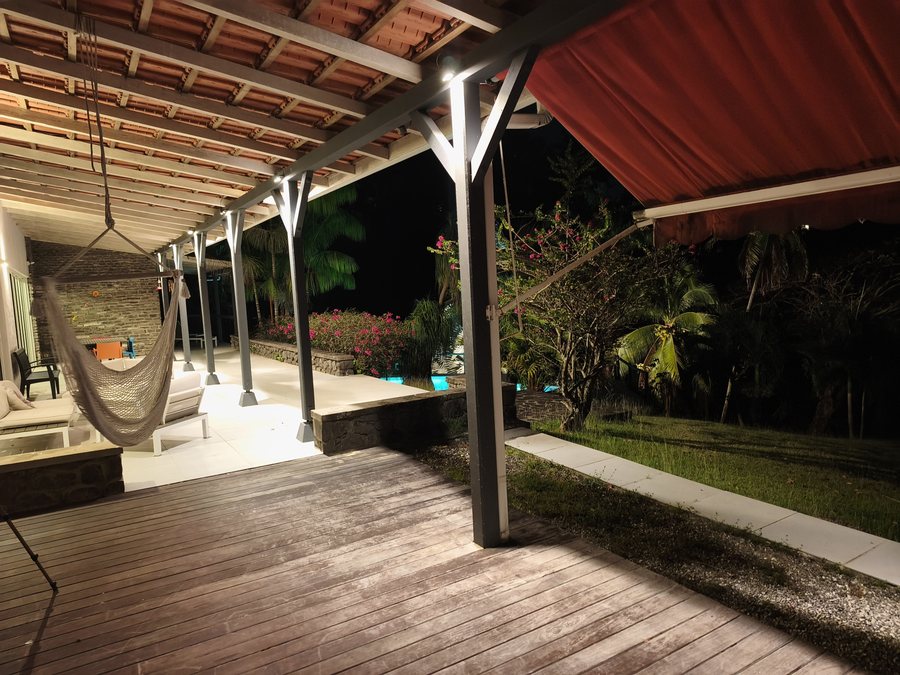 Terrasse en bois et fauteuil suspendu à la tombée du jour, en Martinique